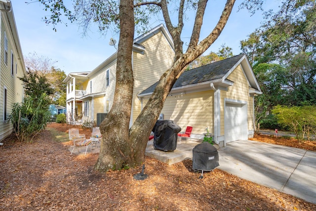 view of home's exterior with a garage, a balcony, and central air condition unit