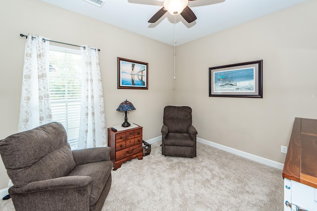 living area featuring light carpet and ceiling fan