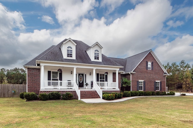 new england style home featuring a porch and a front yard