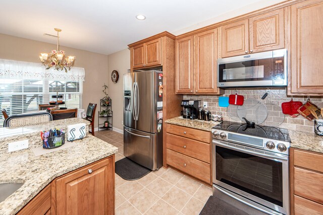 kitchen featuring hanging light fixtures, decorative backsplash, light stone countertops, appliances with stainless steel finishes, and a chandelier