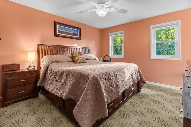 bedroom featuring baseboards, a ceiling fan, and light colored carpet
