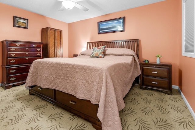 bedroom with a ceiling fan, baseboards, and light colored carpet