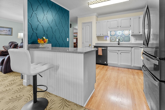 kitchen with stainless steel appliances, light hardwood / wood-style floors, ornamental molding, and white cabinetry