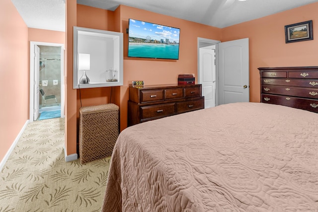 bedroom with baseboards, connected bathroom, and light colored carpet
