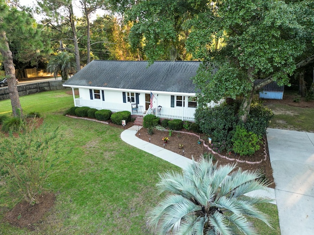 ranch-style house featuring a front lawn, covered porch, and roof with shingles