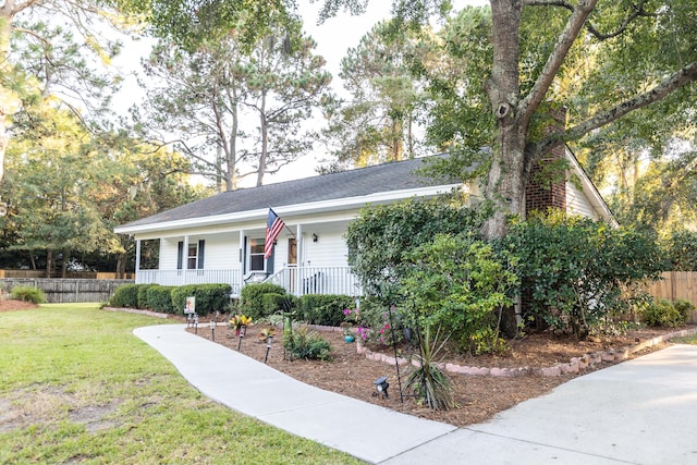 view of front of property featuring a front lawn, covered porch, and fence