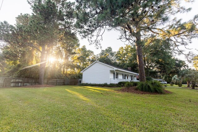 view of yard featuring fence and covered porch