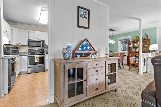 kitchen featuring white cabinets, light wood-style floors, a textured ceiling, and appliances with stainless steel finishes