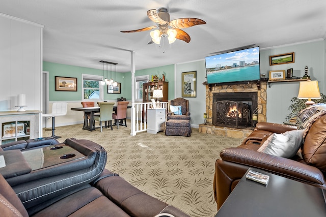 carpeted living room featuring ornamental molding, a fireplace, and ceiling fan