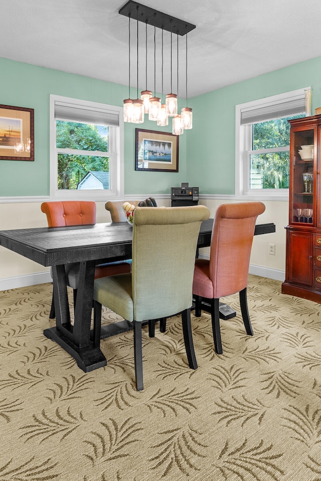 carpeted dining room featuring a chandelier