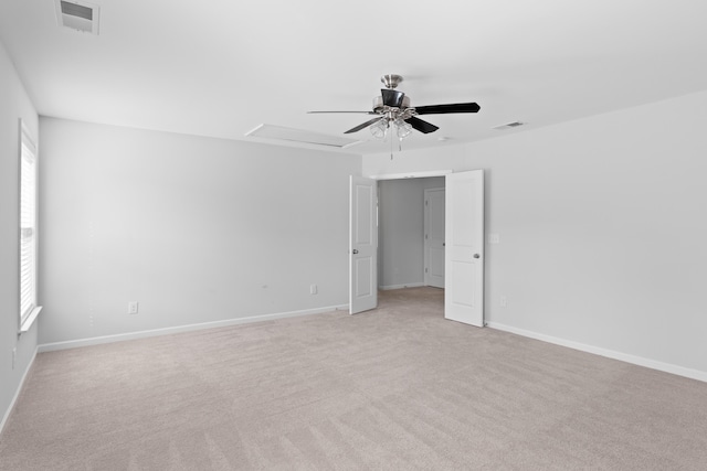 unfurnished room with light carpet, visible vents, and baseboards