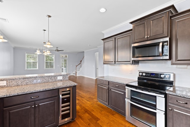 kitchen with beverage cooler, stainless steel appliances, dark brown cabinetry, and crown molding