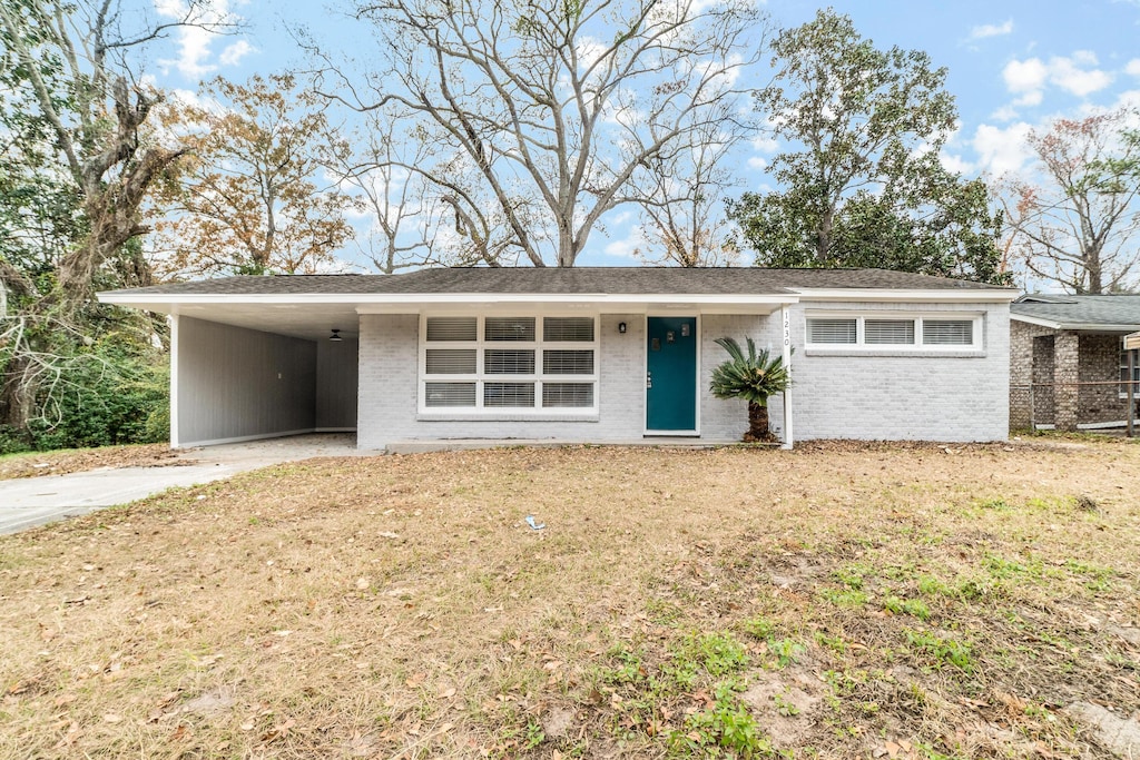 single story home featuring a carport and a front yard