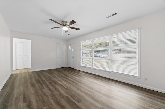 unfurnished room featuring ceiling fan and dark wood-type flooring