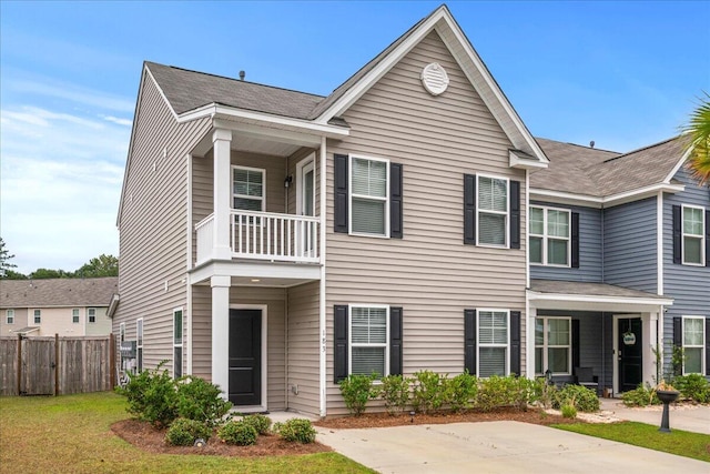 view of front of home featuring a balcony and a front yard