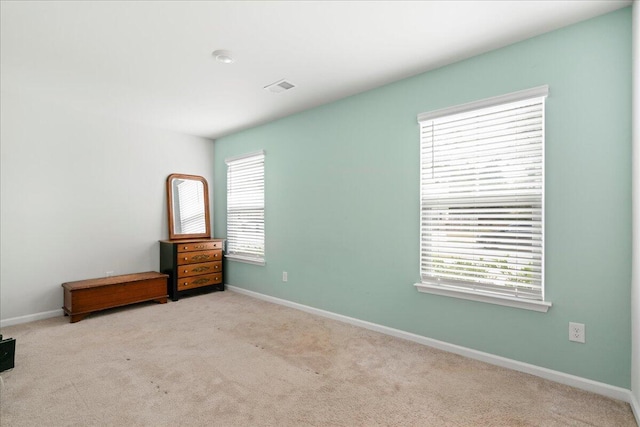 carpeted empty room featuring plenty of natural light