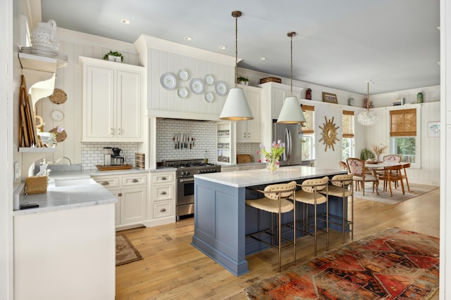 732 Gate Post Dr, Mount Pleasant, SC 29464 - kitchen featuring appliances with stainless steel finishes, light wood-style flooring, decorative backsplash, a kitchen bar, and recessed lighting