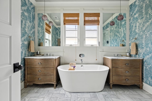 732 Gate Post Dr, Mount Pleasant, SC 29464 - bathroom with wallpapered walls, a freestanding bath, two vanities, and a wainscoted wall