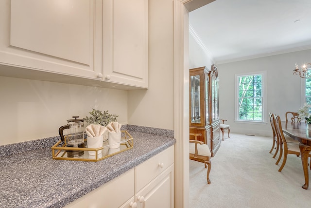 3331 Cottonfield Dr, Mount Pleasant, SC 29466 - kitchen with ornamental molding, light carpet, dark countertops, white cabinetry, and a chandelier