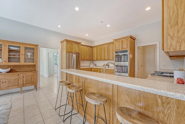 3331 Cottonfield Dr, Mount Pleasant, SC 29466 - kitchen with appliances with stainless steel finishes, a peninsula, light tile patterned flooring, recessed lighting, and a breakfast bar area