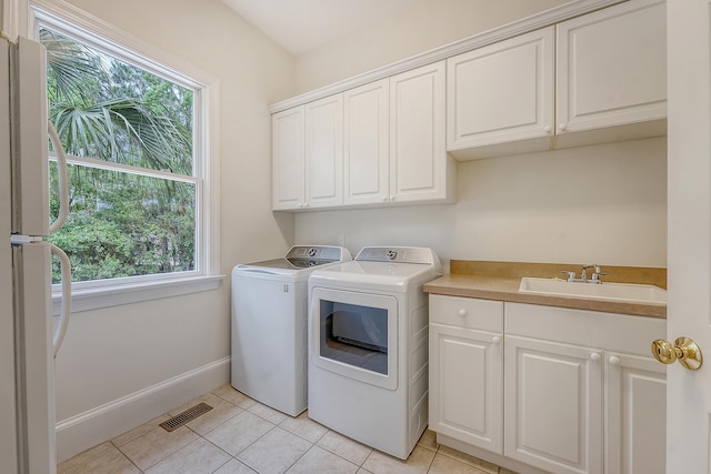 3331 Cottonfield Dr, Mount Pleasant, SC 29466 - laundry room with cabinet space, washing machine and clothes dryer, plenty of natural light, and light tile patterned floors
