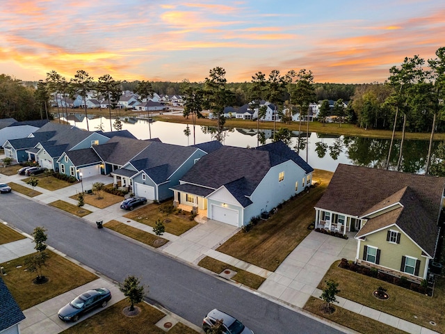 aerial view at dusk featuring a water view