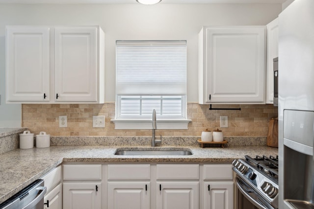 kitchen with white cabinetry, appliances with stainless steel finishes, sink, and decorative backsplash