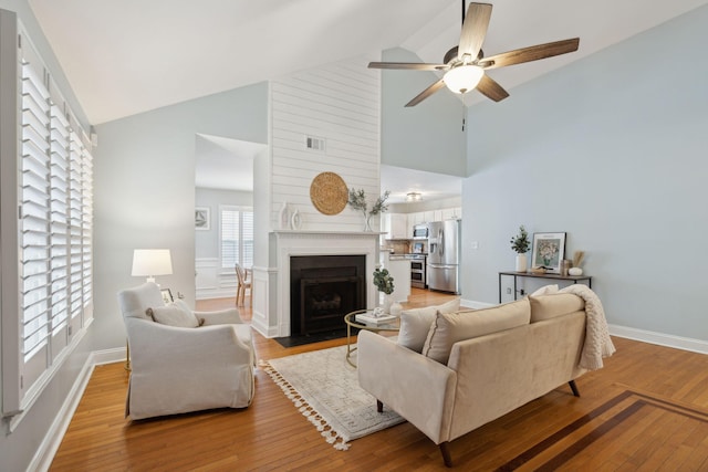 living room with high vaulted ceiling, hardwood / wood-style floors, and ceiling fan