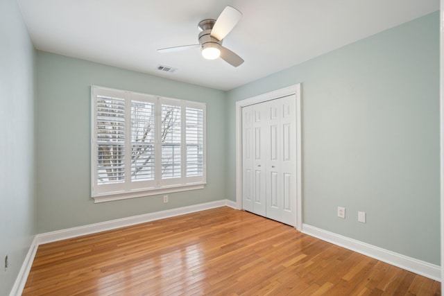 unfurnished bedroom with ceiling fan, light hardwood / wood-style floors, and a closet