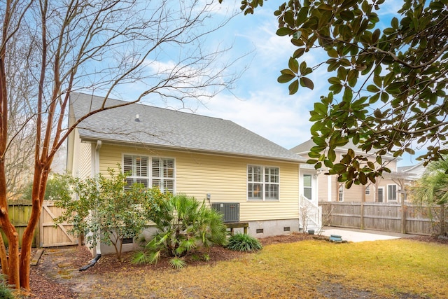 rear view of house featuring a yard and central air condition unit