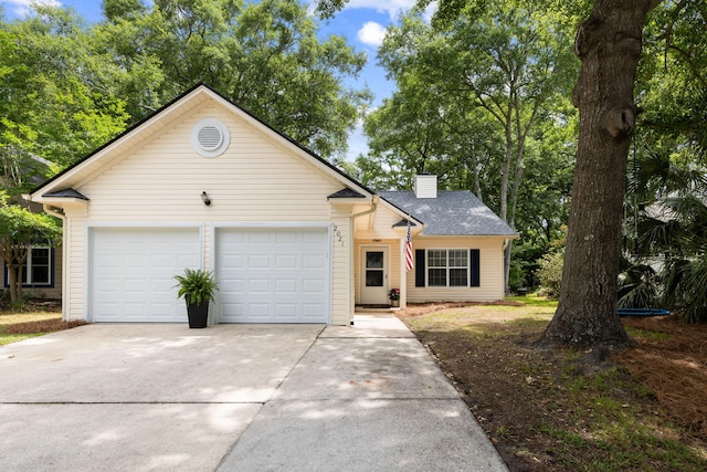 view of front of home with driveway, a chimney, and an attached garage
