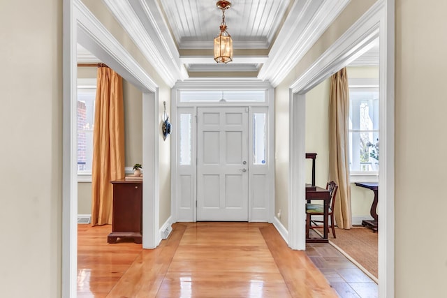 foyer entrance with baseboards, light wood-style flooring, and crown molding