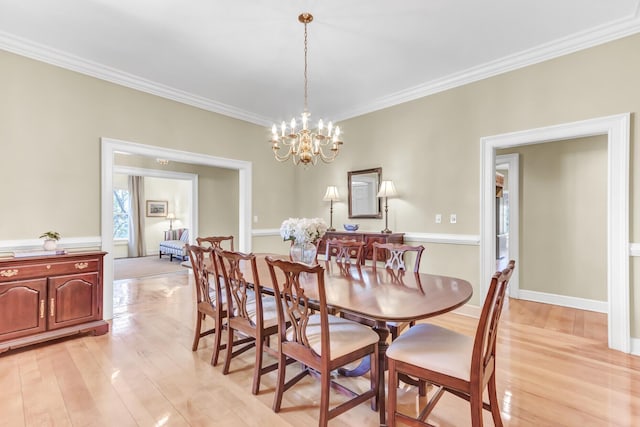 dining room with a notable chandelier, light wood-style flooring, and ornamental molding