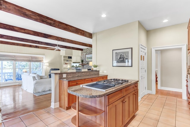 kitchen featuring open floor plan, light tile patterned floors, a peninsula, stainless steel gas stovetop, and open shelves