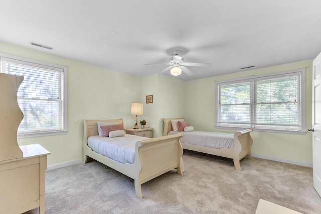 bedroom featuring baseboards, multiple windows, visible vents, and carpet flooring