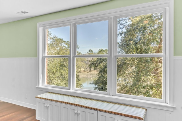 interior details featuring wood finished floors, visible vents, and wainscoting