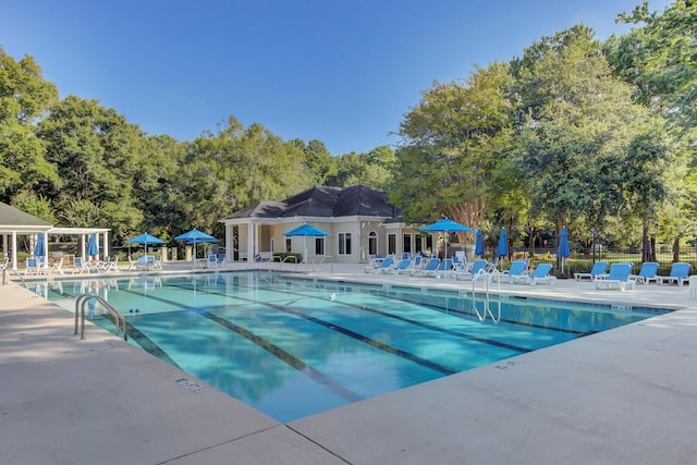 pool with a patio area and fence