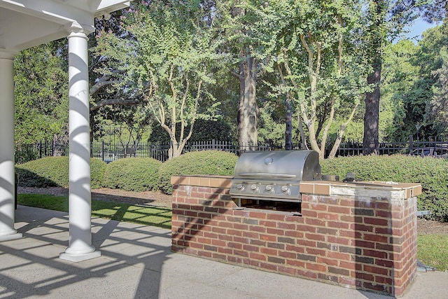 view of patio featuring exterior kitchen, area for grilling, and a fenced backyard