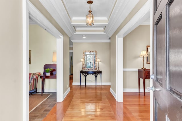 entrance foyer featuring crown molding, baseboards, and light wood finished floors