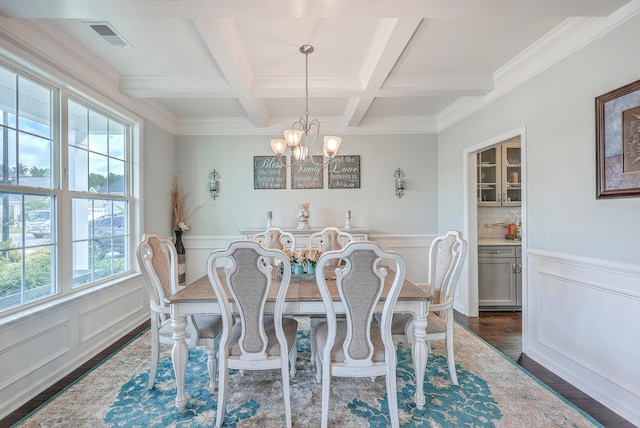 dining area with an inviting chandelier, dark hardwood / wood-style floors, beam ceiling, ornamental molding, and coffered ceiling