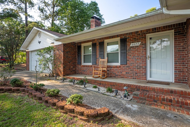 6427 Quimby Rd, Dalzell, SC 29040 - view of front facade with a porch, brick siding, a chimney, a garage, and driveway