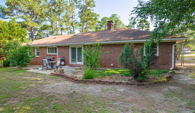 6427 Quimby Rd, Dalzell, SC 29040 - back of house featuring a chimney, brick siding, and a patio