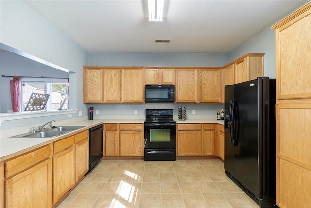 kitchen with black appliances, light brown cabinetry, and sink