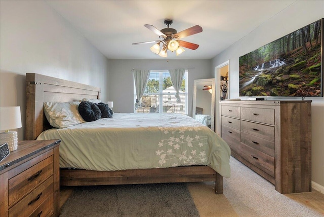 carpeted bedroom with ceiling fan, a walk in closet, and a closet