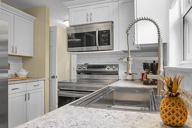 49 Crosscreek Dr, Charleston, SC 29412 - kitchen featuring appliances with stainless steel finishes, decorative backsplash, and white cabinetry