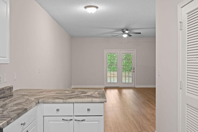 4591 Great Oak Dr, North Charleston, SC 29418 - kitchen with wood finished floors, open floor plan, ceiling fan, a textured ceiling, and white cabinets