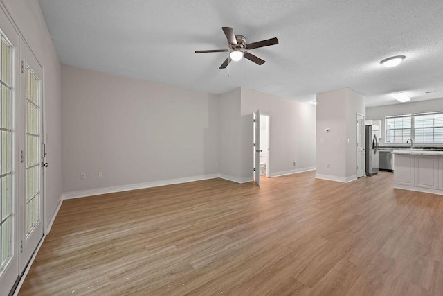 4591 Great Oak Dr, North Charleston, SC 29418 - unfurnished living room featuring a ceiling fan, baseboards, a sink, and light wood-style flooring