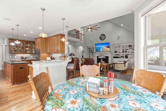 8605 Refuge Point Cir N, Charleston, SC 29420 - dining space featuring light wood finished floors, ceiling fan, recessed lighting, a warm lit fireplace, and high vaulted ceiling