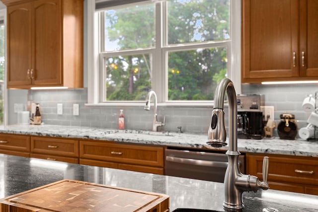 8605 Refuge Point Cir N, Charleston, SC 29420 - kitchen with a sink, decorative backsplash, brown cabinetry, and light stone countertops
