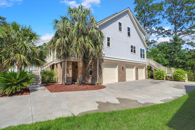 8605 Refuge Point Cir N, Charleston, SC 29420 - view of property exterior featuring stairway, an attached garage, brick siding, and driveway